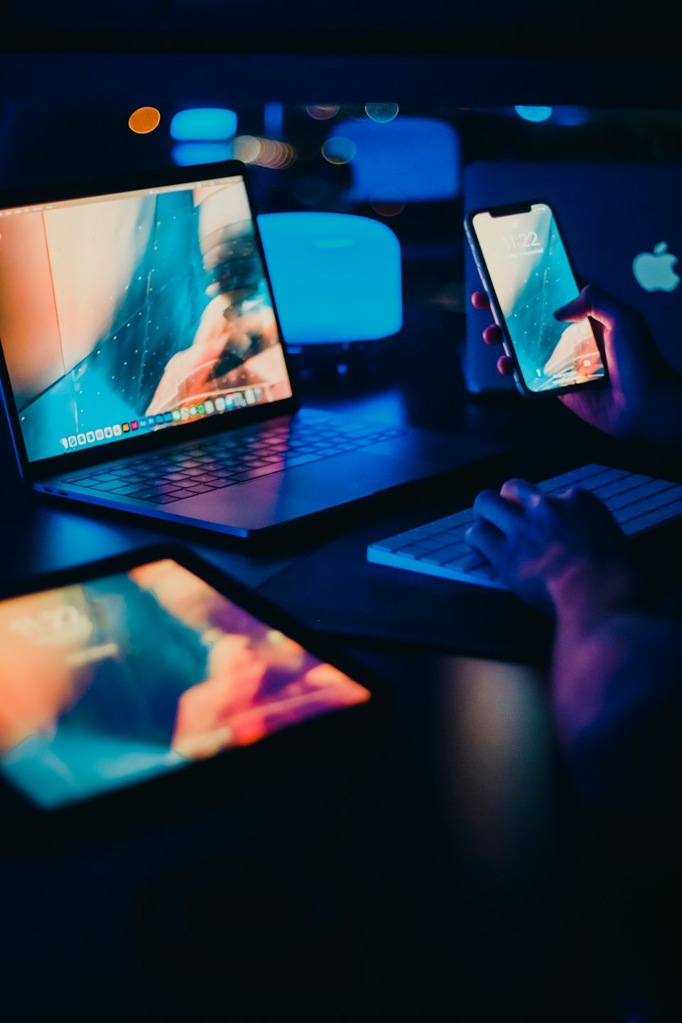 Mani che usano smartphone, laptop e tablet per lavorare.